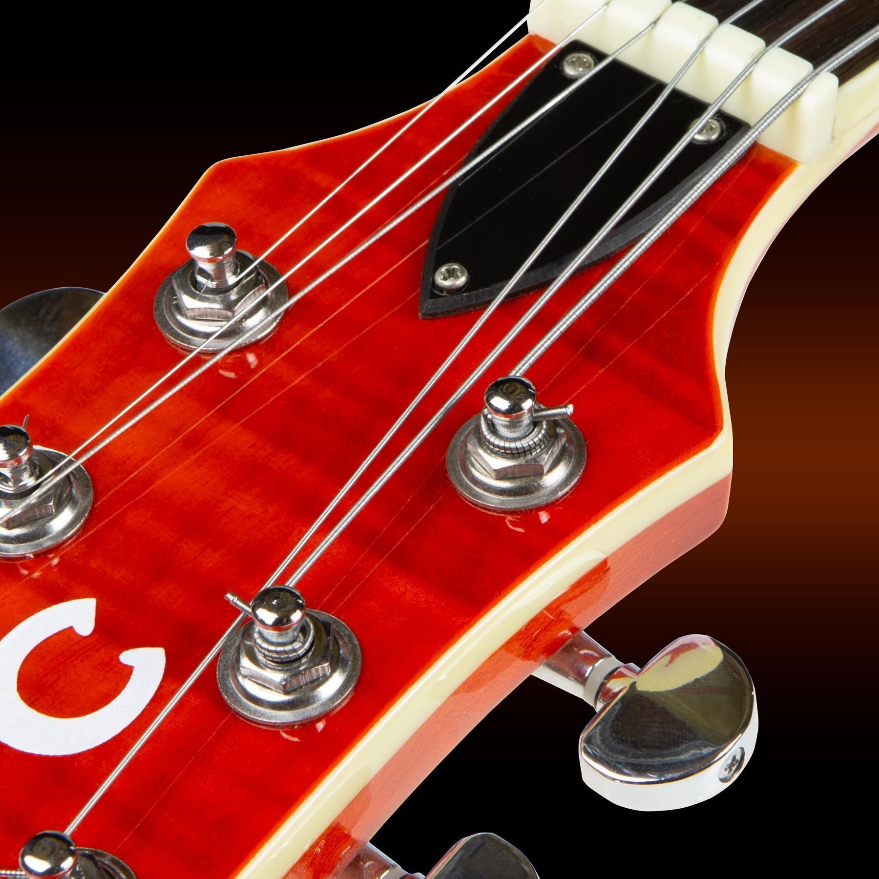 GHS Precision Flatwound 800 extra-light electric guitar strings — close-up of the strings installed on a red guitar headstock — Slide 7 of 9