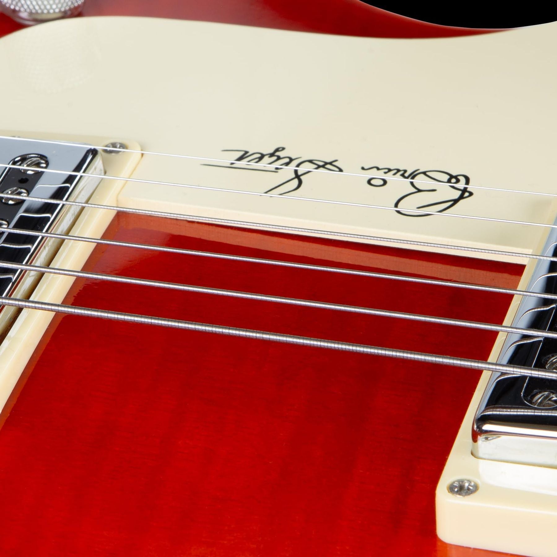 GHS Precision Flatwound 800 extra-light electric guitar strings — close-up of the strings across a red-and-cream guitar body — Slide 8 of 9